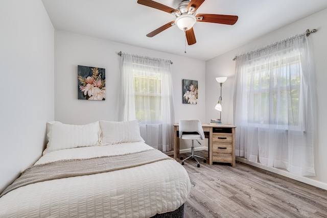 bedroom with multiple windows, light hardwood / wood-style flooring, and ceiling fan