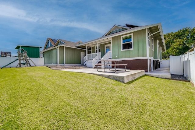 rear view of property featuring a patio and a lawn