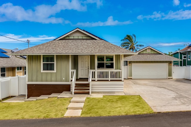 view of front of home with a garage, a front lawn, solar panels, and covered porch