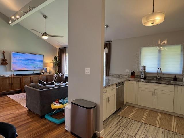 15 Kulanihakoi St Unit 9E, Kihei, HI 96753 - kitchen with a sink, dishwasher, stone countertops, lofted ceiling, and light wood-style floors