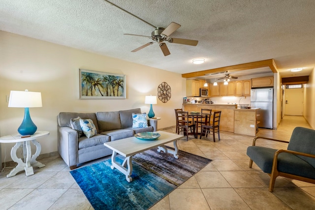 living room featuring ceiling fan, light tile patterned floors, and a textured ceiling