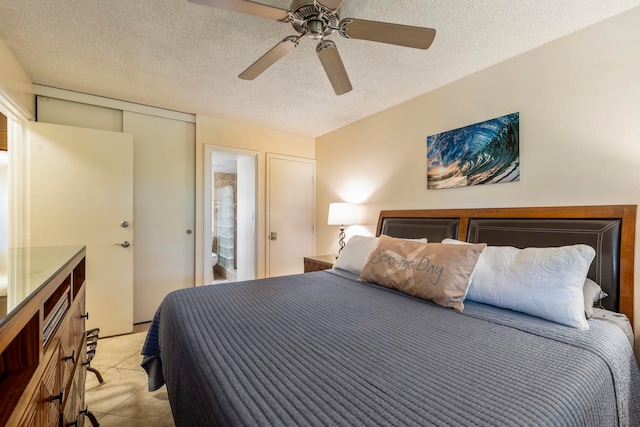 bedroom featuring a textured ceiling, ceiling fan, ensuite bathroom, and a closet