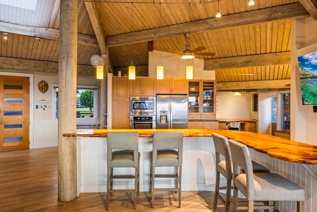 kitchen with a breakfast bar, wooden ceiling, light hardwood / wood-style flooring, ceiling fan, and stainless steel appliances