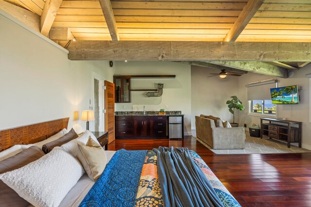 bedroom with beamed ceiling, hardwood / wood-style flooring, stainless steel refrigerator, and sink