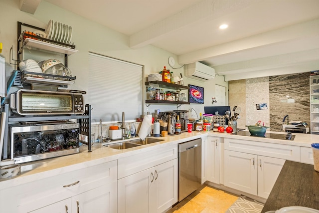 kitchen with white cabinetry, sink, beamed ceiling, stainless steel dishwasher, and an AC wall unit