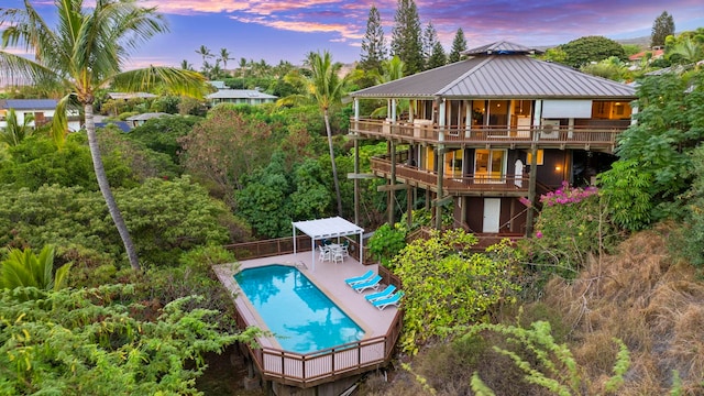 pool at dusk featuring a deck