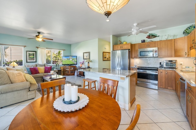 tiled dining area with ceiling fan and sink