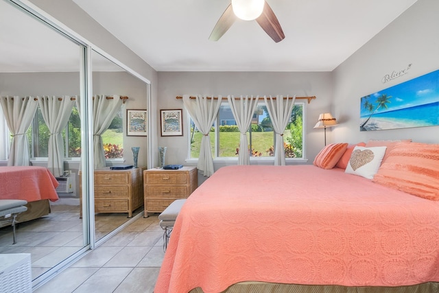 tiled bedroom featuring ceiling fan and a closet