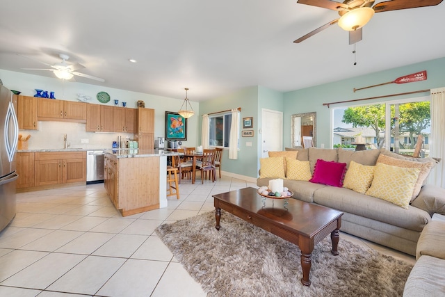 tiled living room with ceiling fan and sink