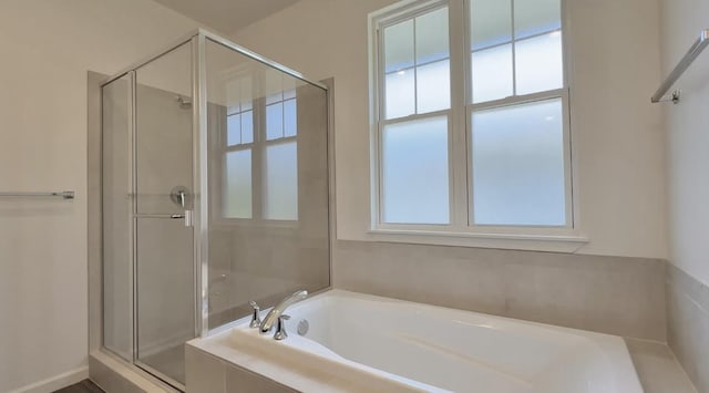 bathroom featuring a shower stall, plenty of natural light, and a bath