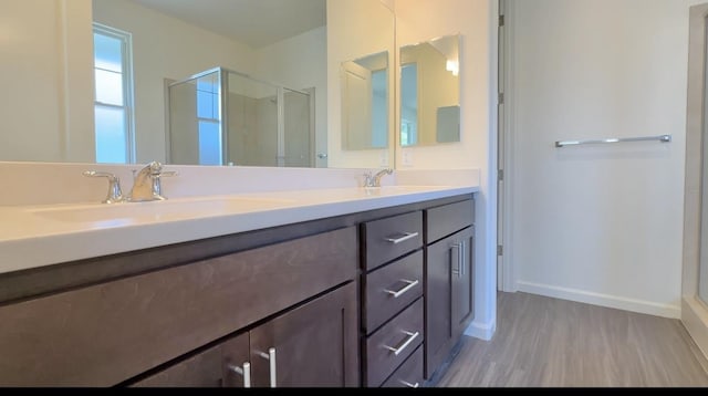full bath with wood finished floors, a sink, and a stall shower