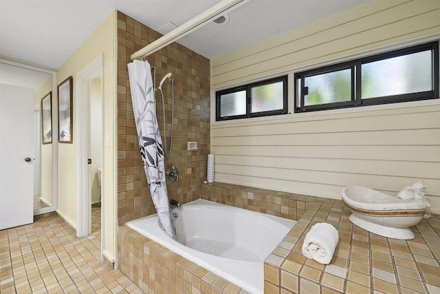 bathroom with toilet, tile patterned floors, and shower / bathtub combination with curtain