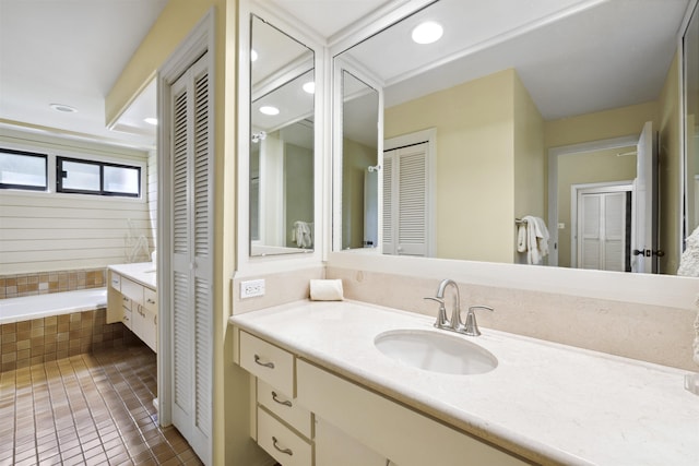 bathroom featuring vanity, tiled tub, and tile patterned floors