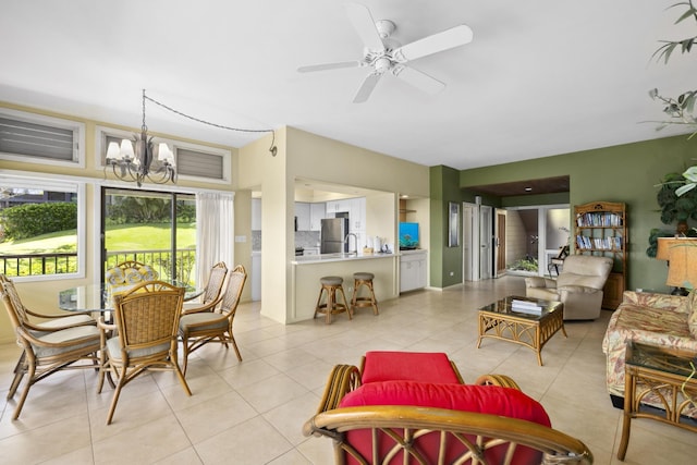 sunroom / solarium featuring ceiling fan with notable chandelier