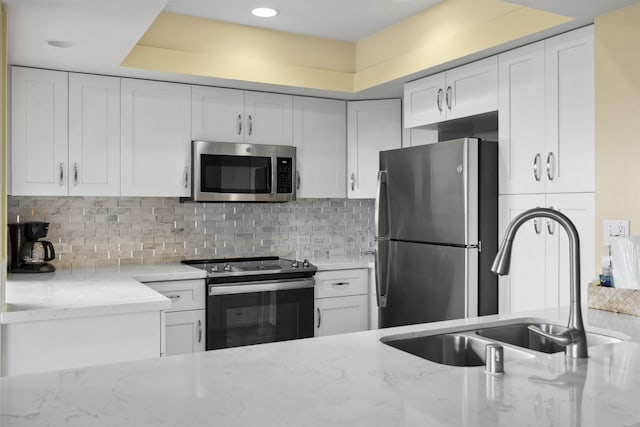 kitchen with light tile patterned floors, stainless steel dishwasher, sink, decorative light fixtures, and white cabinets