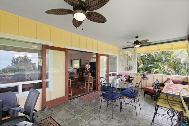 sunroom / solarium featuring ceiling fan