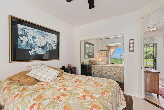 bedroom with light tile patterned flooring, ceiling fan, and a closet