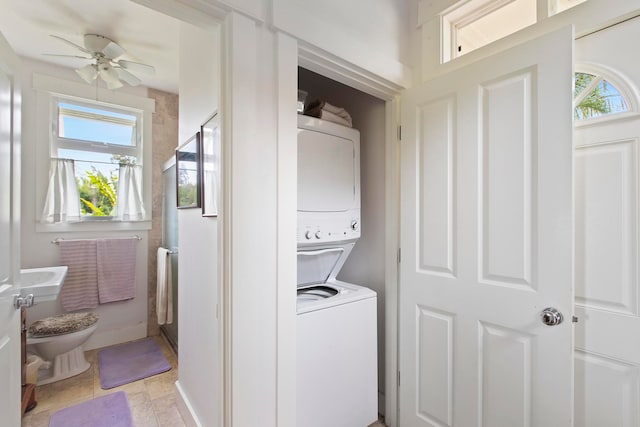 washroom with stacked washer and dryer and ceiling fan