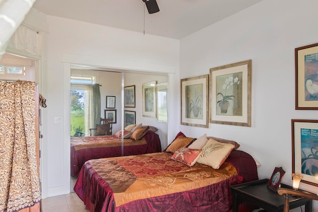 bedroom with ceiling fan, light tile patterned flooring, and a closet