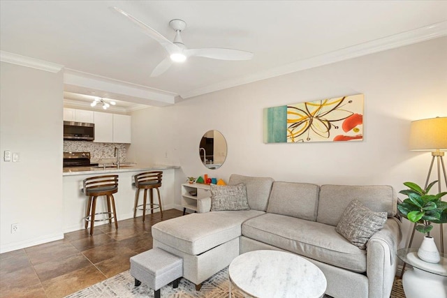 living room with ornamental molding, dark tile flooring, ceiling fan, and sink