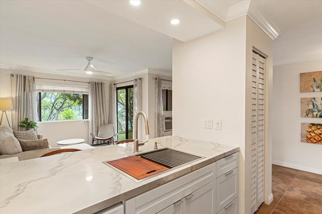 kitchen with crown molding, dark tile floors, ceiling fan, and sink