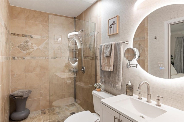 bathroom featuring tile walls, vanity, toilet, and walk in shower