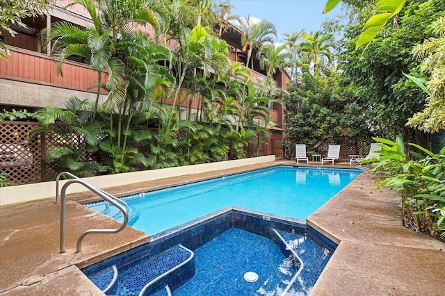 view of pool featuring an in ground hot tub