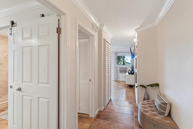 hall featuring ornamental molding, a barn door, and tile flooring