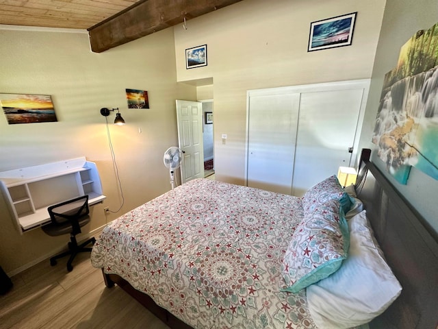 bedroom with a closet, hardwood / wood-style floors, wooden ceiling, and vaulted ceiling