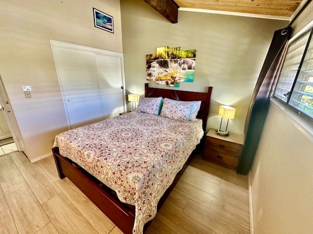 bedroom with wood-type flooring and beam ceiling