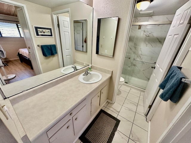 bathroom with vanity, a textured ceiling, wood-type flooring, toilet, and a shower with shower door