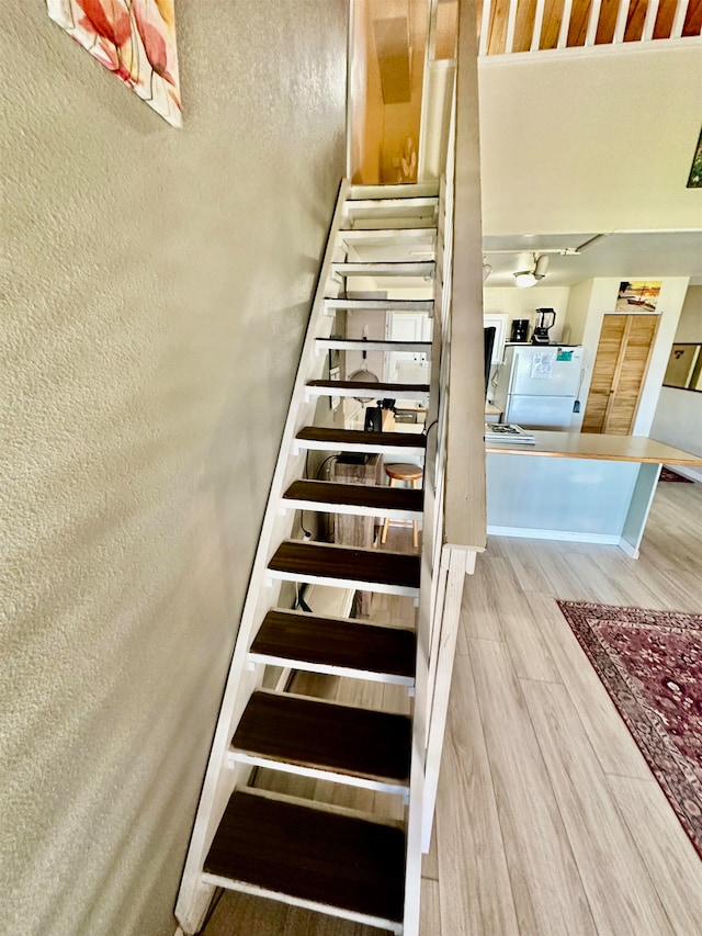 staircase with hardwood / wood-style flooring