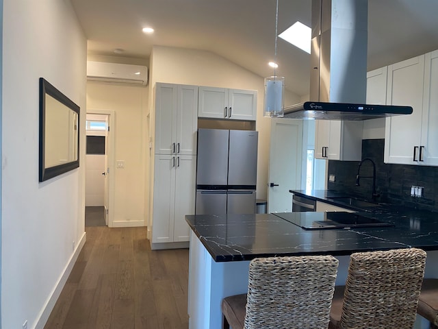 kitchen with island exhaust hood, stainless steel appliances, sink, a breakfast bar area, and kitchen peninsula