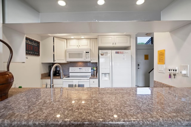kitchen featuring dark stone counters, recessed lighting, a sink, white cabinetry, and white appliances