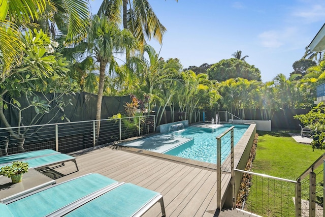 view of swimming pool with pool water feature, a deck, and a yard