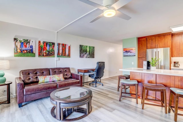 living room with ceiling fan and light hardwood / wood-style flooring