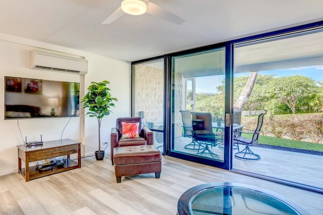 living area with light hardwood / wood-style floors, a wall mounted AC, expansive windows, and ceiling fan