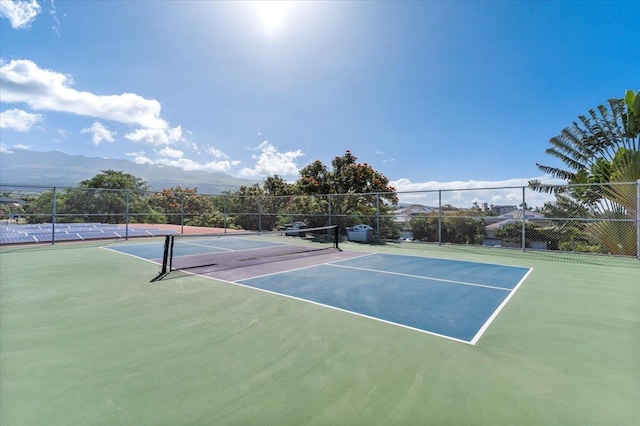 view of tennis court featuring a mountain view