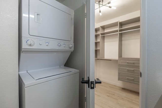 480 Kenolio Rd Unit 24-202, Kihei, HI 96753 - laundry room featuring stacked washer and clothes dryer, light wood-style flooring, and baseboards