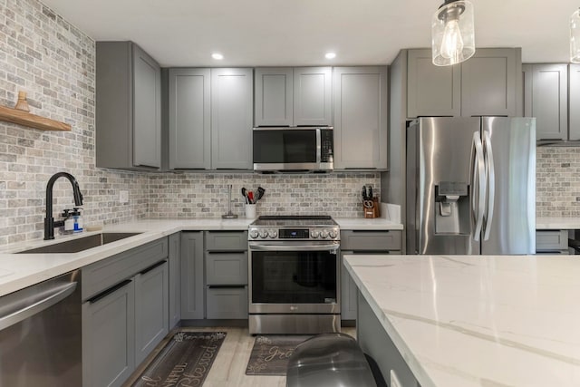 480 Kenolio Rd Unit 24-202, Kihei, HI 96753 - kitchen with stainless steel appliances, gray cabinets, a sink, backsplash, and light stone counters