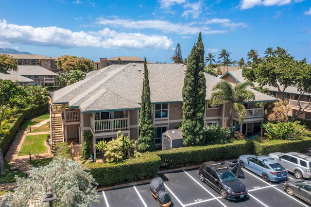 480 Kenolio Rd Unit 24-202, Kihei, HI 96753 - back of house featuring uncovered parking and a shingled roof