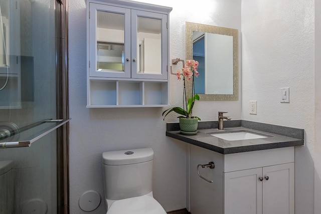 bathroom with vanity, an enclosed shower, and toilet