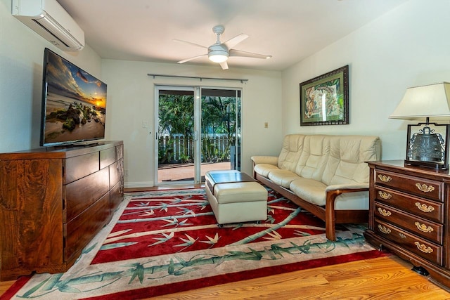 living room featuring a wall mounted air conditioner, light hardwood / wood-style floors, and ceiling fan