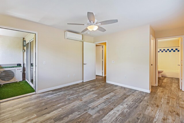 10 Polohina Ln Unit 2-3, Lahaina, HI 96761 - unfurnished bedroom featuring a wall mounted AC, wood finished floors, baseboards, and ceiling fan