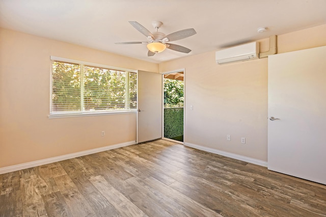 10 Polohina Ln Unit 2-3, Lahaina, HI 96761 - unfurnished room with a wall unit AC, wood finished floors, a ceiling fan, baseboards, and a smoke detector