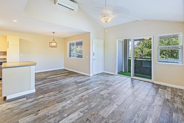 10 Polohina Ln Unit 2-3, Lahaina, HI 96761 - unfurnished living room featuring dark wood finished floors, lofted ceiling, a wall unit AC, baseboards, and a ceiling fan