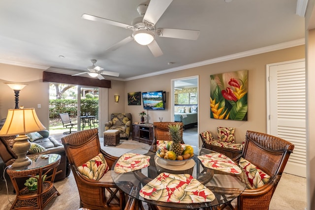 dining space featuring crown molding, ceiling fan, and light carpet