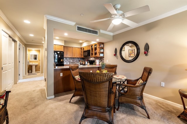 dining space with crown molding, light colored carpet, and ceiling fan