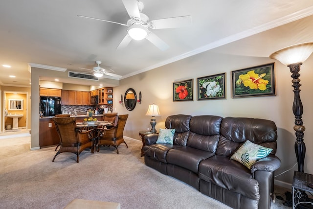 carpeted living room with ceiling fan and ornamental molding