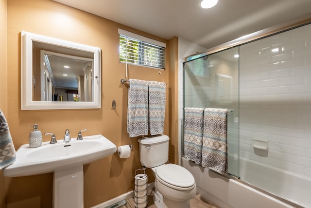 bathroom with shower / bath combination with glass door and toilet